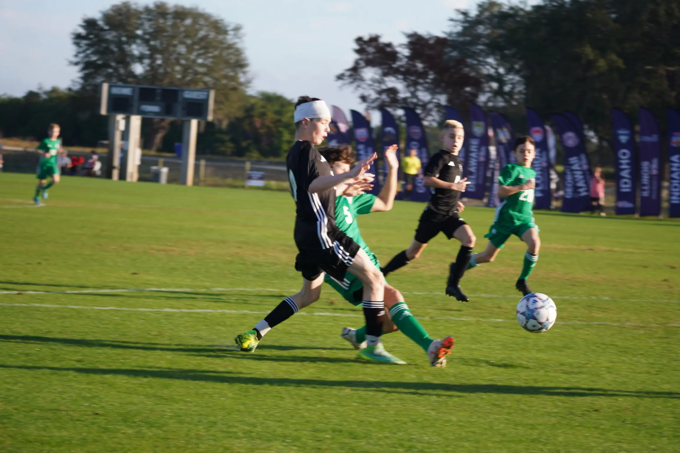 Daylen Hammon in pink ODP bib with white headband dribbling past green-bibbed defender at ODP Regionals Orlando FL January 2024